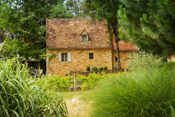 Gramíneas alrededor de una casa típica del Périgord